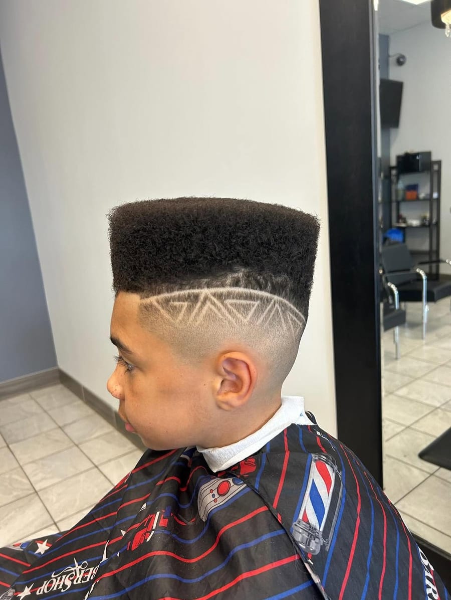High-top fade haircut with a shaved geometric design